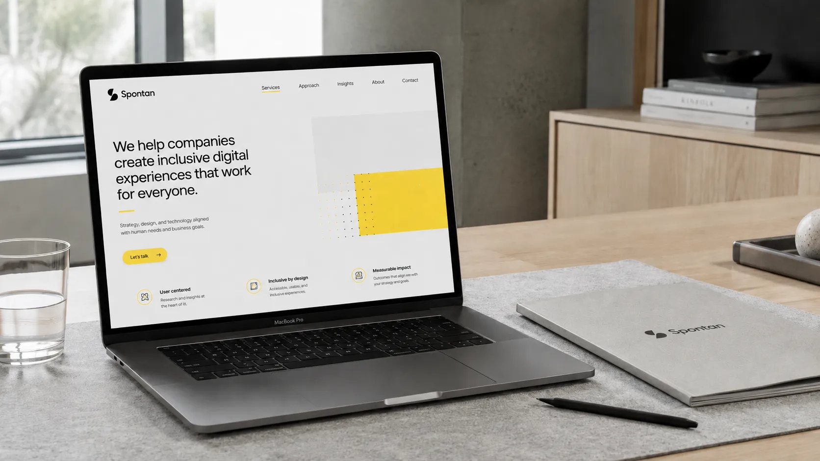 The Spontan site open on a laptop, the wordmark on a notebook beside it